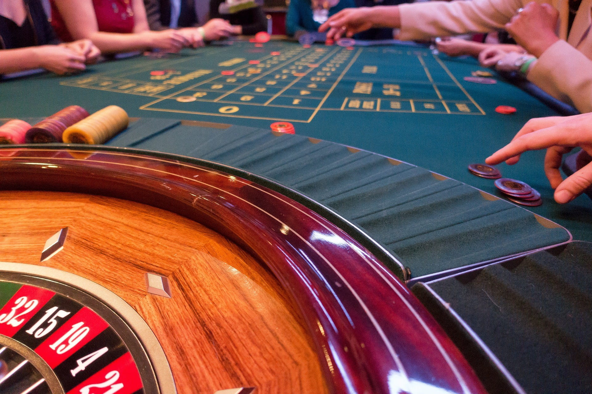An einem Roulette-Tisch sitzen vier Spieler.
