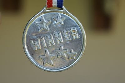 Auf einer silbernen Medaille steht das Wort Winner und fünf Sterne.